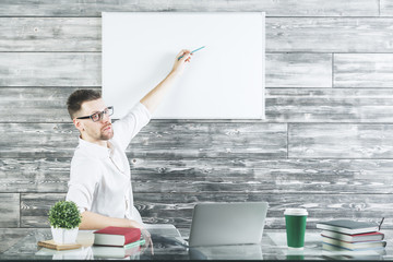 Canvas Print - Attractive man at workplace with whiteboard