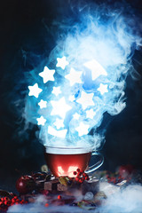 Wall Mural - Cup of tea with dense steam and shining stars in conceptual astronomy scene. Dark food photography with smoke.