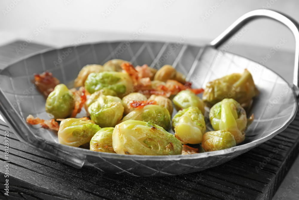 Dish with brussel sprouts and bacon on table