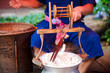 Man Unwinding And Reeling Silk Cocoons In Factory
