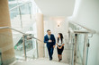 © alfa27 - Businessman and Business woman walking up stairs with bags to office.