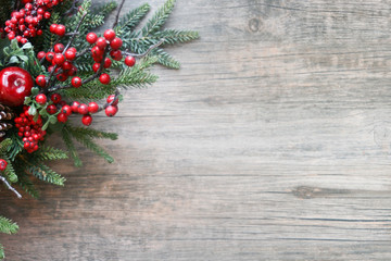 Wall Mural - christmas evergreen branches and berries in corner over rustic wooden background