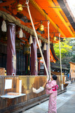 Fototapeta Londyn - Tourist woman in Yukata Kimono Dress Praying by ringing the golden bell