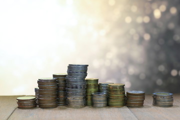 Wall Mural - Coin stack with blur light dreamy bokeh background. Business, finance and saving concept.