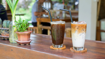 iced latte and americano coffee on a wooden table.