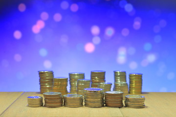 Coin stack with blur light dreamy bokeh background. Business, finance and saving concept.