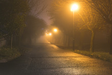 Dark Alley In Heavy Fog Iluminated By Street Lamps