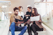 © Mediteraneo - Happy group of friends sitting on the stairs in the school or college