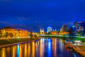 Wall Mural - Night view of the illuminated riverside of the Neris river in Vilnius, Lithuania.