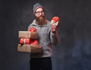 Bearded male holds Christmas gifts.