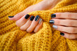 Beautiful hands with manicure in a knitted warm sweater.Manicure - Beauty treatment photo of nice manicured woman fingernails.