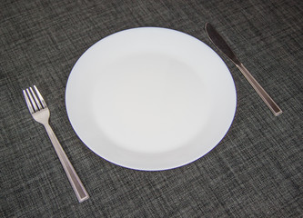 Empty dish, knife and fork on table