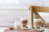Glasses with latte macchiato on table indoors