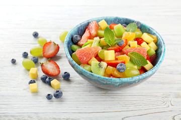 Sticker - Bowl of fresh fruit salad on wooden table