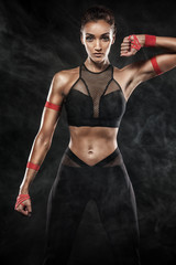 Wall Mural - A strong athletic, woman on black background wearing in the sportswear, fitness and sport motivation.