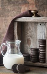 Wall Mural - Chocolate cookies with creamy filling with jug of milk