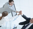 © ASDF - view from the top.members of the business team giving each other a high five above the Desk.