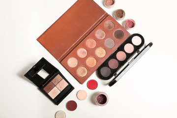 Wall Mural - Kit of makeup palettes in nude color with loose eyeshadows over a white background