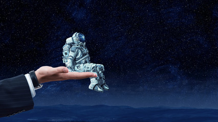 Wall Mural - spaceman in male hand. mixed media