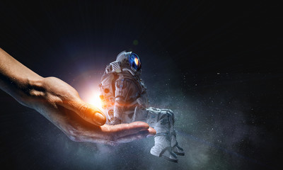Wall Mural - spaceman in male hand. mixed media