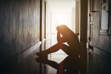 Silhouette Of Sad And Depressed Women Sitting At Walkway Of Condominium Or Office With Backlit And Lens Flare,sad Mood,feel Tired, Lonely And Unhappy.Vintage Style.
