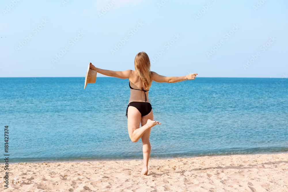 Young woman with nice body on sea beach