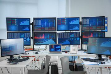 Canvas Print - Monitors with stock data on table in office