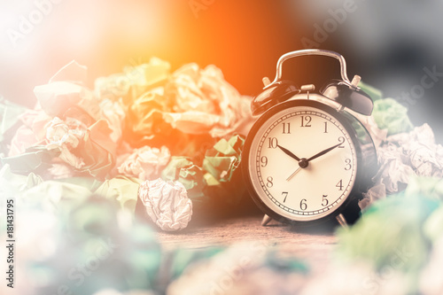 Fotografie, Obraz Alarm clock in a wastepaper concept for a time waste of time with cork board tex