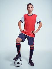 Wall Mural - Photo of teen boy in sportswear holding soccer ball