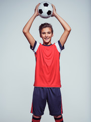 Wall Mural - smiling teen boy in sportswear holding soccer ball