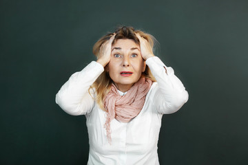 Wall Mural - Omg. Studio shot of terrified middle aged female staring at camera with mouth opened, tearing hair out, feeling shocked or stressed, being completely lost, responding to bad negative news or problem