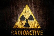 Yellow Radioactive (ionizing Radiation) Danger Symbol With Word Radioactive Painted Below The Sign On A Massive Concrete Wall With Dark Rustic Grunge Brown Texture Background.
