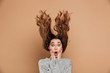 Close-up photo of attractive shocked woman with funny hairstyle touching her face, looking at camera