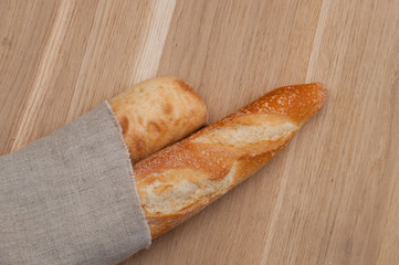 Two baguettes wrapped in a linen napkin