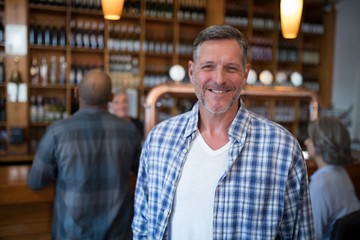 Wall Mural - Happy man standing in bar