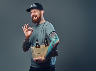 A man holds a wooden box with beer bottles.