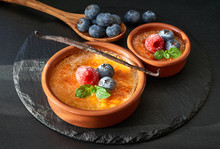 Creme Brulee With Raspberry, Blueberry And Mint Leaves On Dark Slate Stone