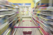 © Laymanzoom - Supermarket aisle with empty shopping cart, Supermarket store abstract blurred background with shopping cart