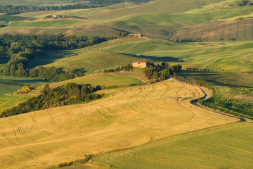 Magnificent spring landscape.Beautiful view of typical tuscan farm house, green wave hills, cypresses trees, hay bales, olive trees, beautiful golden fields and meadows.Tuscany, Italy, Europe