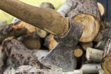 Fototapeta Na sufit - An ax stuck in a stump. A woodpile. Background