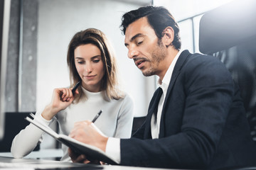 Group of two business person at working process.Young professionals work with new market project. Blurred background.Horizontal.