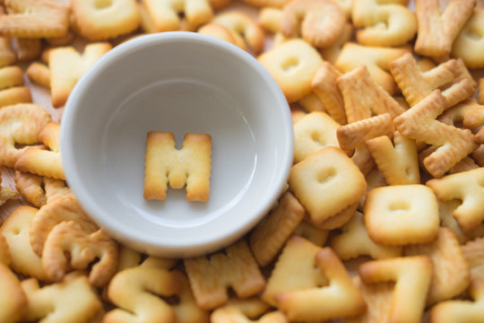 Alphabet biscuit in ceramic cups letters M