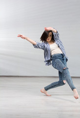 Young urban woman dancing. Young beautiful dancer girl in dynamic pose on studio background. Modern dance education school.