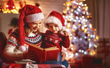 Wall Mural - christmas eve. family mother and baby reading magic book at home