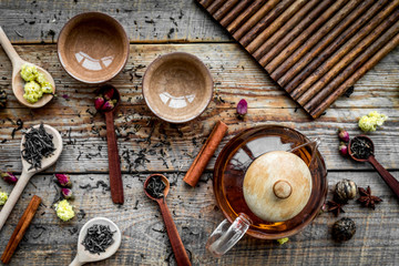 Wall Mural - tea party set. tea pot, cups, dried tea leaves, fllowers, spices on wooden background top view