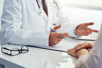 Male doctor sitting at a table and consulting with his patient