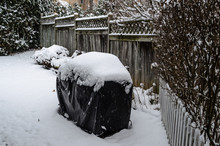 3/4 Frame View Of A Snow Covered Barbeque  In A Backyard Snowfall