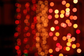 Christmas lights bokeh background. Orange, yellow and red lights on black background