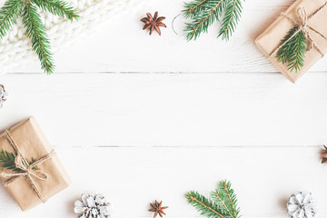 Christmas composition. Christmas gifts, fir tree branches, knitted blanket on white wooden background. Flat lay, top view, copy space