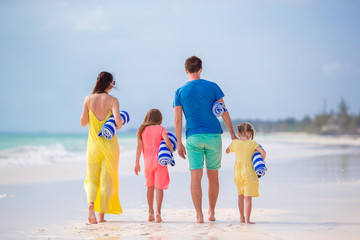 Back view of a young family on tropical beach